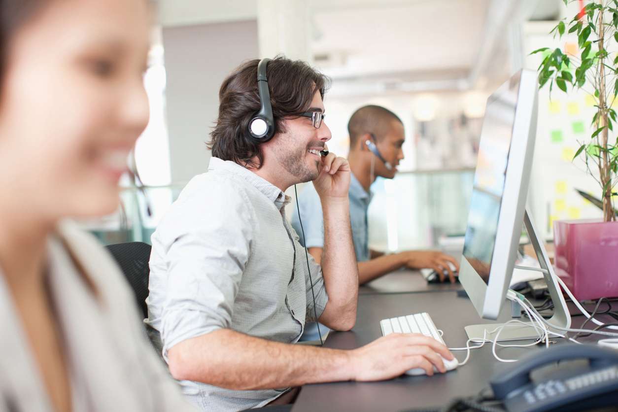 Group of customer service representatives working in an office setup - benefits of outsourcing.