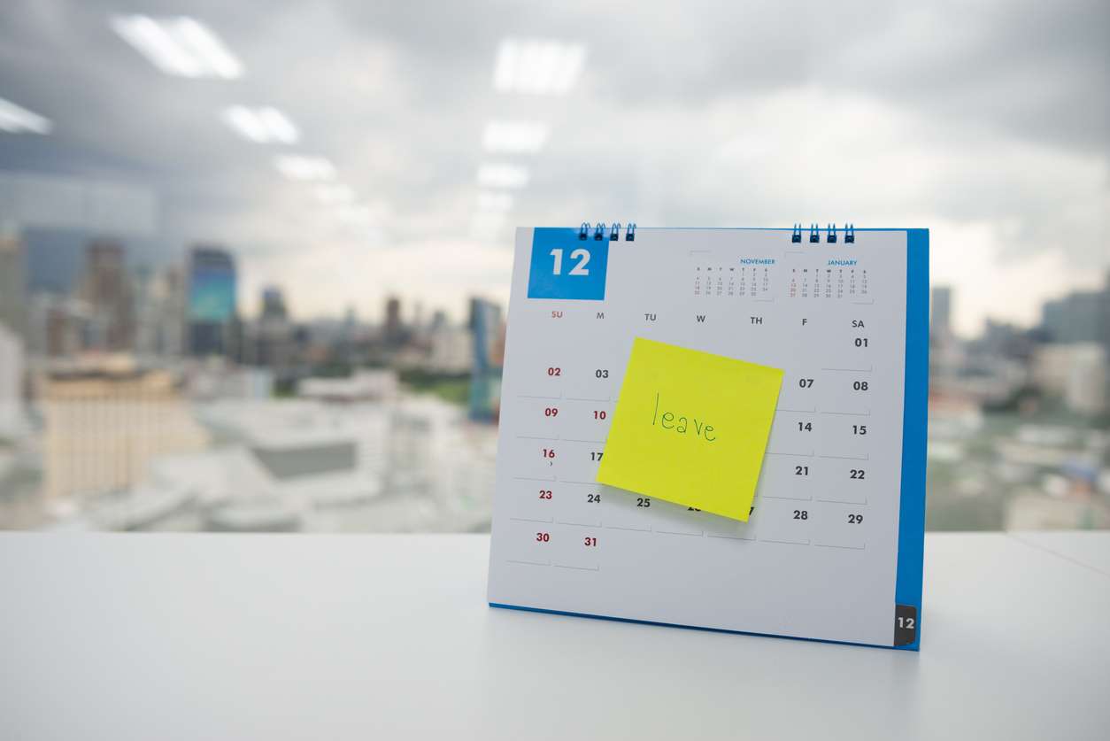 Calendar with the word "leave" written on a post-it note - annual leave entitlement for employees.