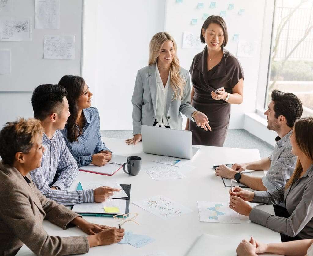 Two businesswomen support the training and skill development of employees when hiring in Canada.