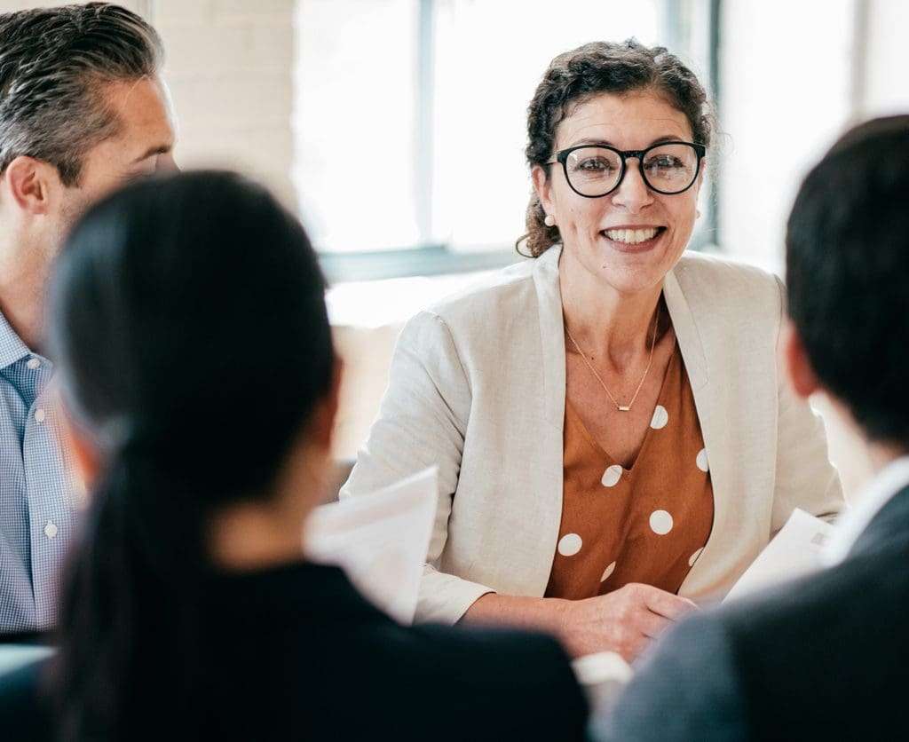 Canadian employees in the office are discussing local regulations and compliance standards, which enhance customer engagement and conversions.