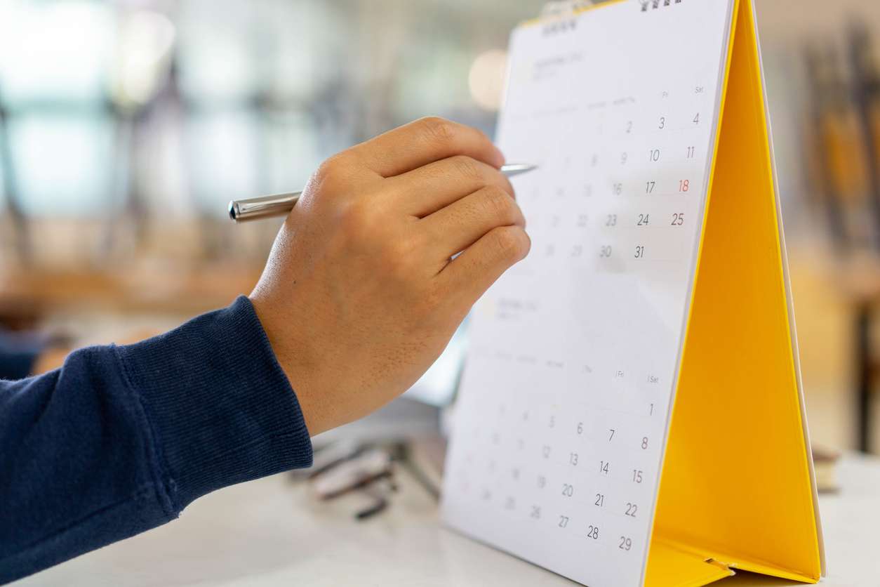 Managing your employees' entitlement to leave credits. • BrightR Businessman counting the days on a calendar - a concept of managing employee leaves.