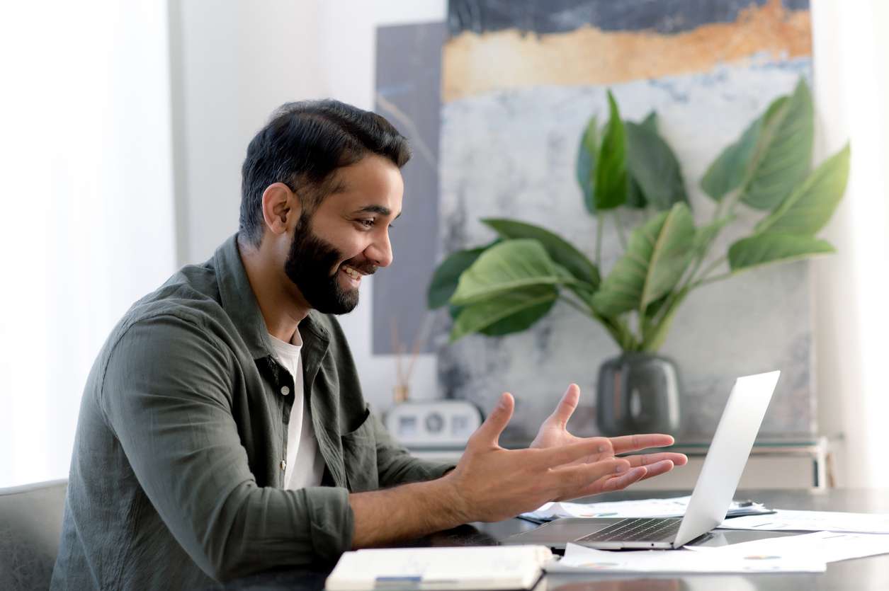 Encouraging open chat channel for team conversations. • BrightR Improving team building for remote workers - A male employee on a video conference call with his colleague.