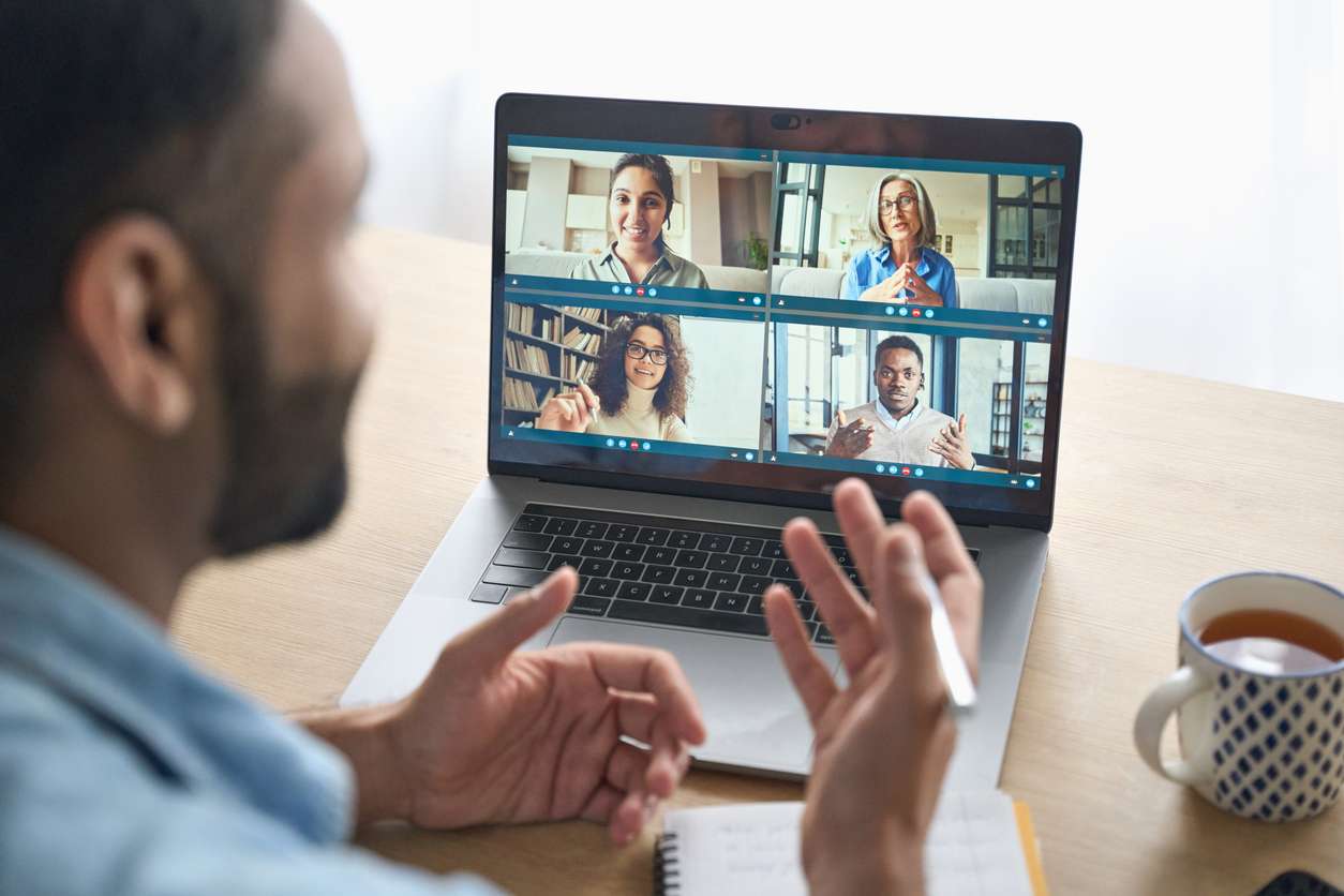 Fostering good company culture - A businessman having a meeting with his employees through video call.