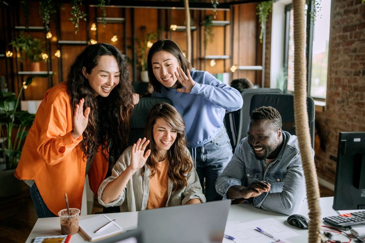 Company culture for employees - A group of diverse employees speaking with their colleagues working remotely.