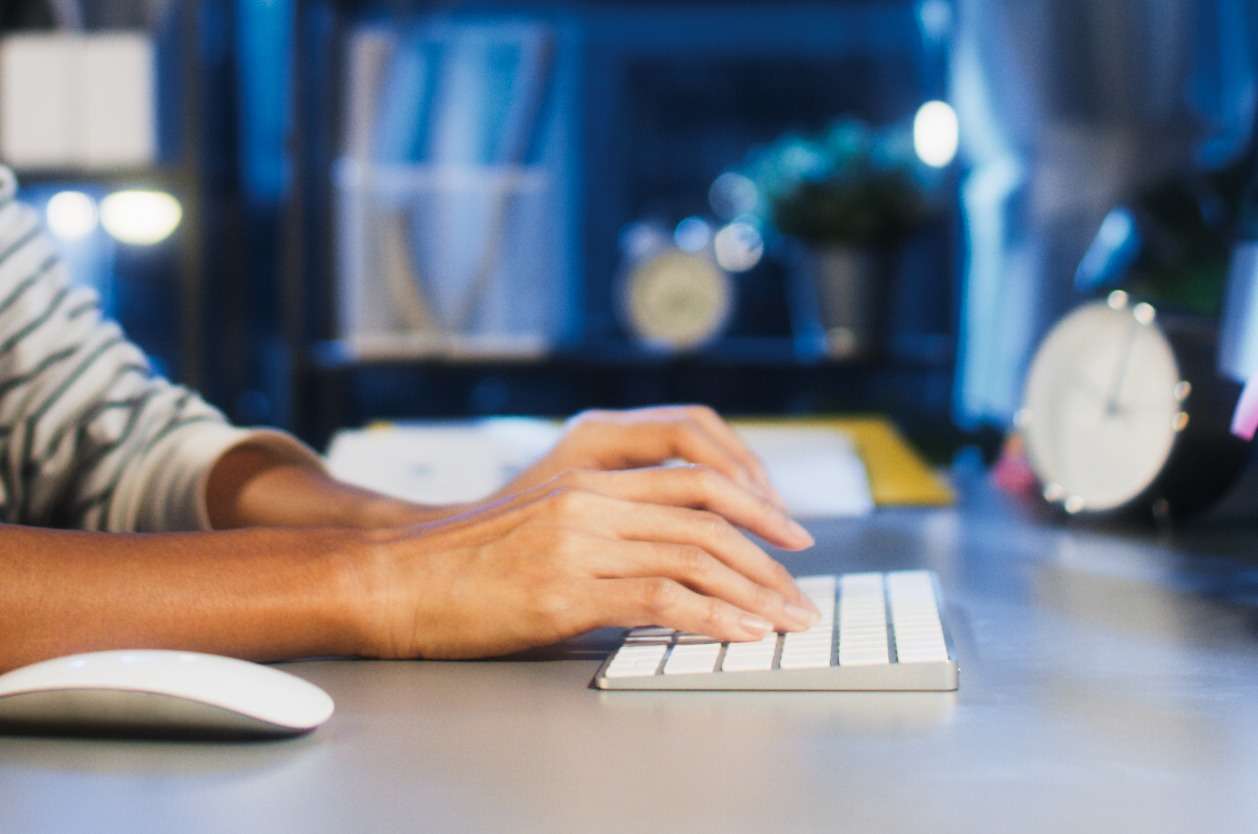 Adapting internal communications policy - A male employee working at home typing on his computer keyboard.