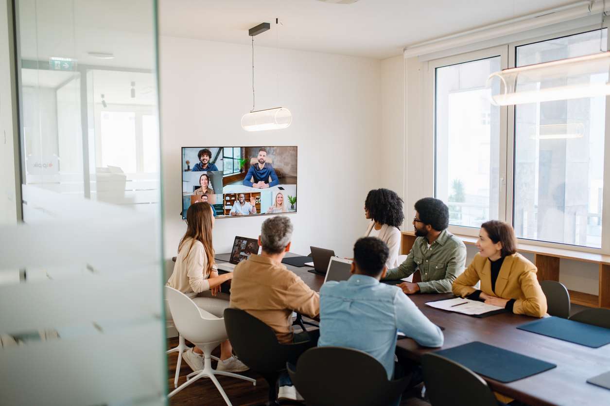 Internationally compliant internal communications - A group of employees having a virtual meeting with their colleagues working outside of the office.