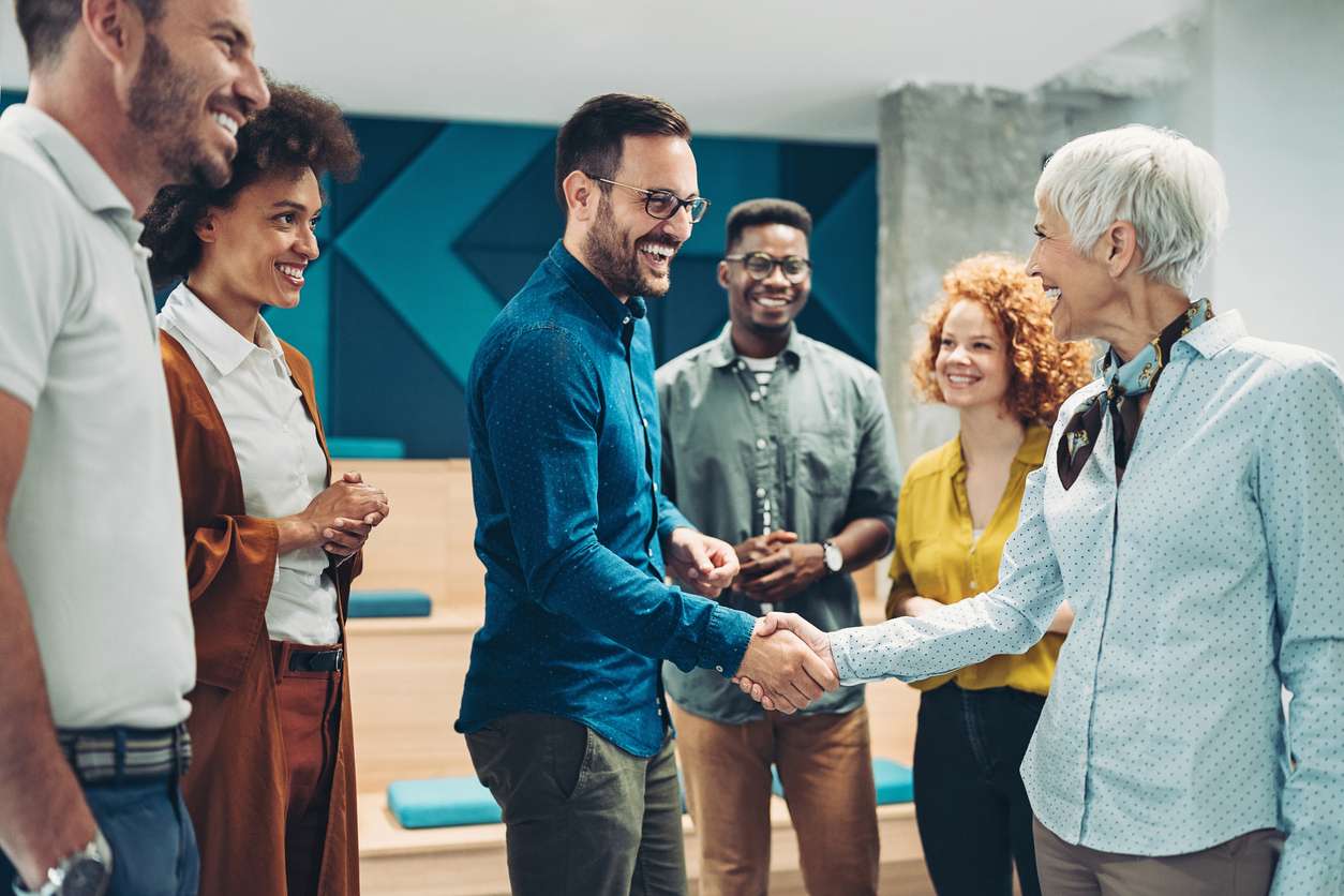 Global workforce management - A businessman shaking hands with a businesswoman.