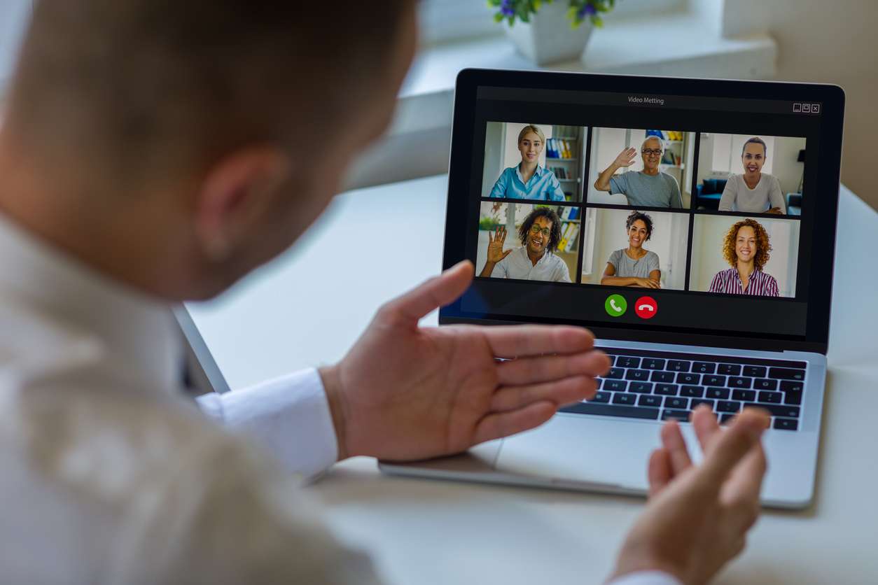 Global workforce management - A businessman having a meeting with his remote employees.