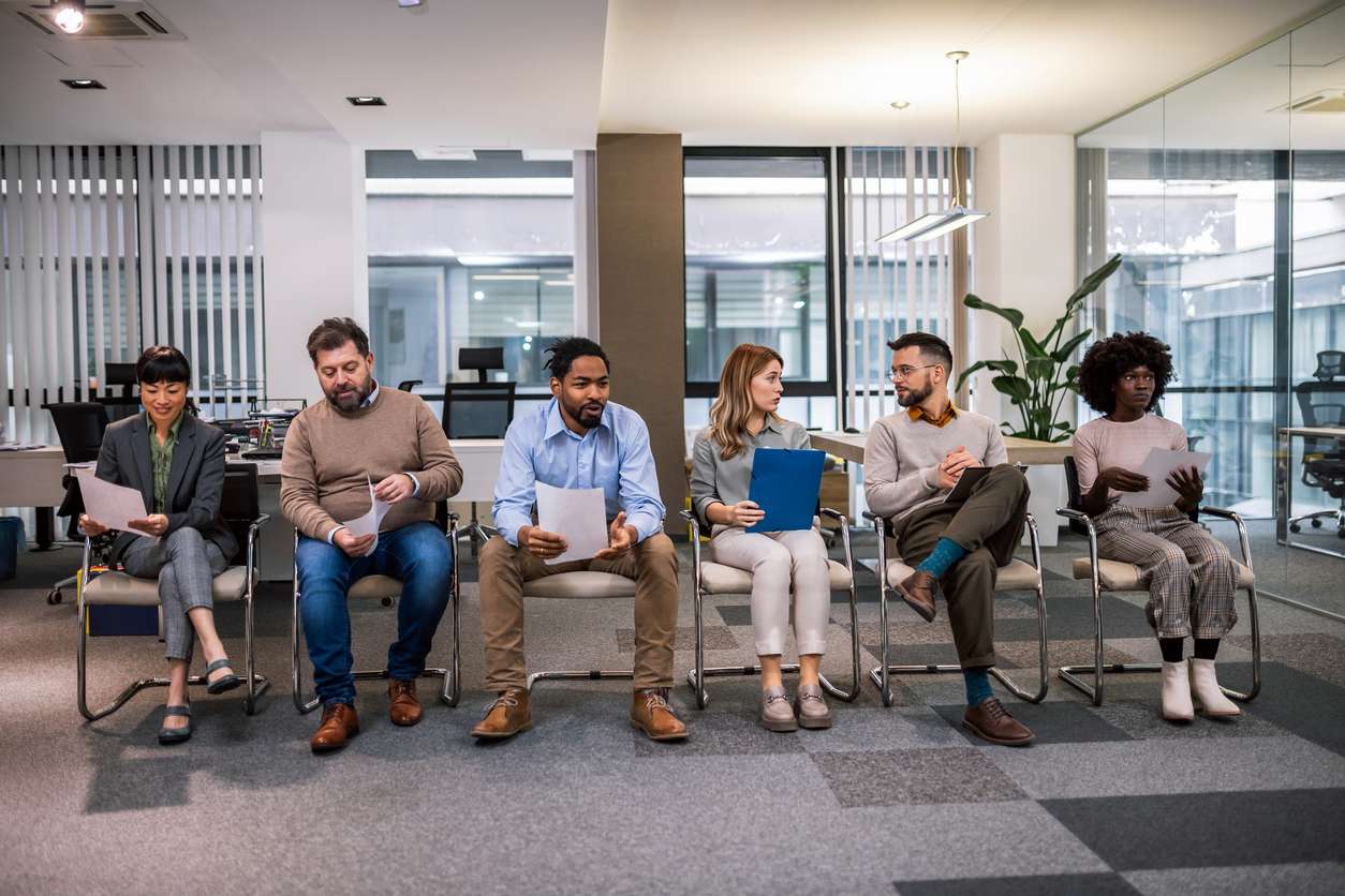 Global workforce management - A group of employees lining up for an interview.