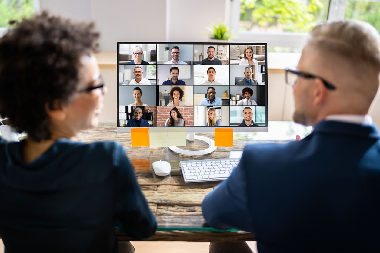 Remote team collaboration tools - Two businesspeople having a meeting with their remote team using a video conferencing platform.