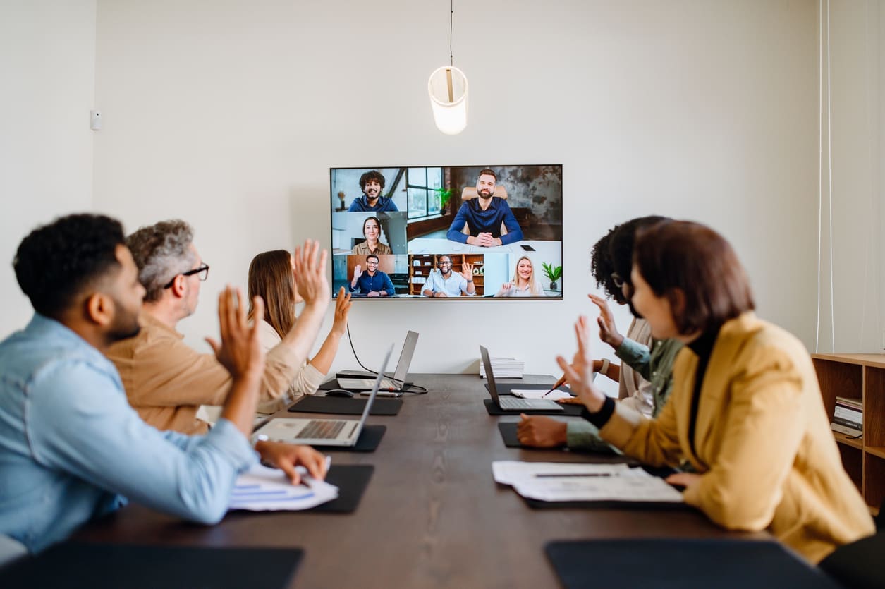 Remote onboarding process - A team of employees welcoming new hires through a virtual meeting.