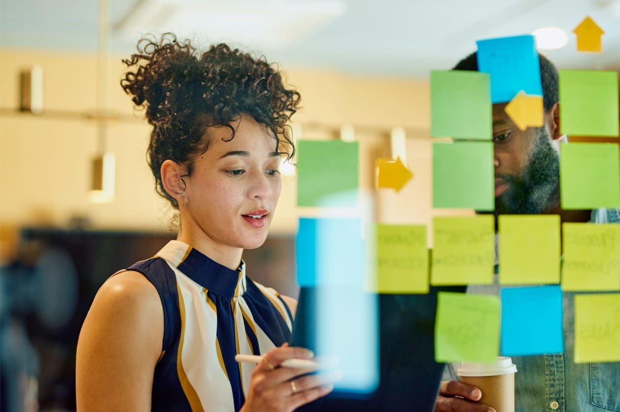 Building global expansion strategies - Two business owners writing down business ideas on sticky notes.