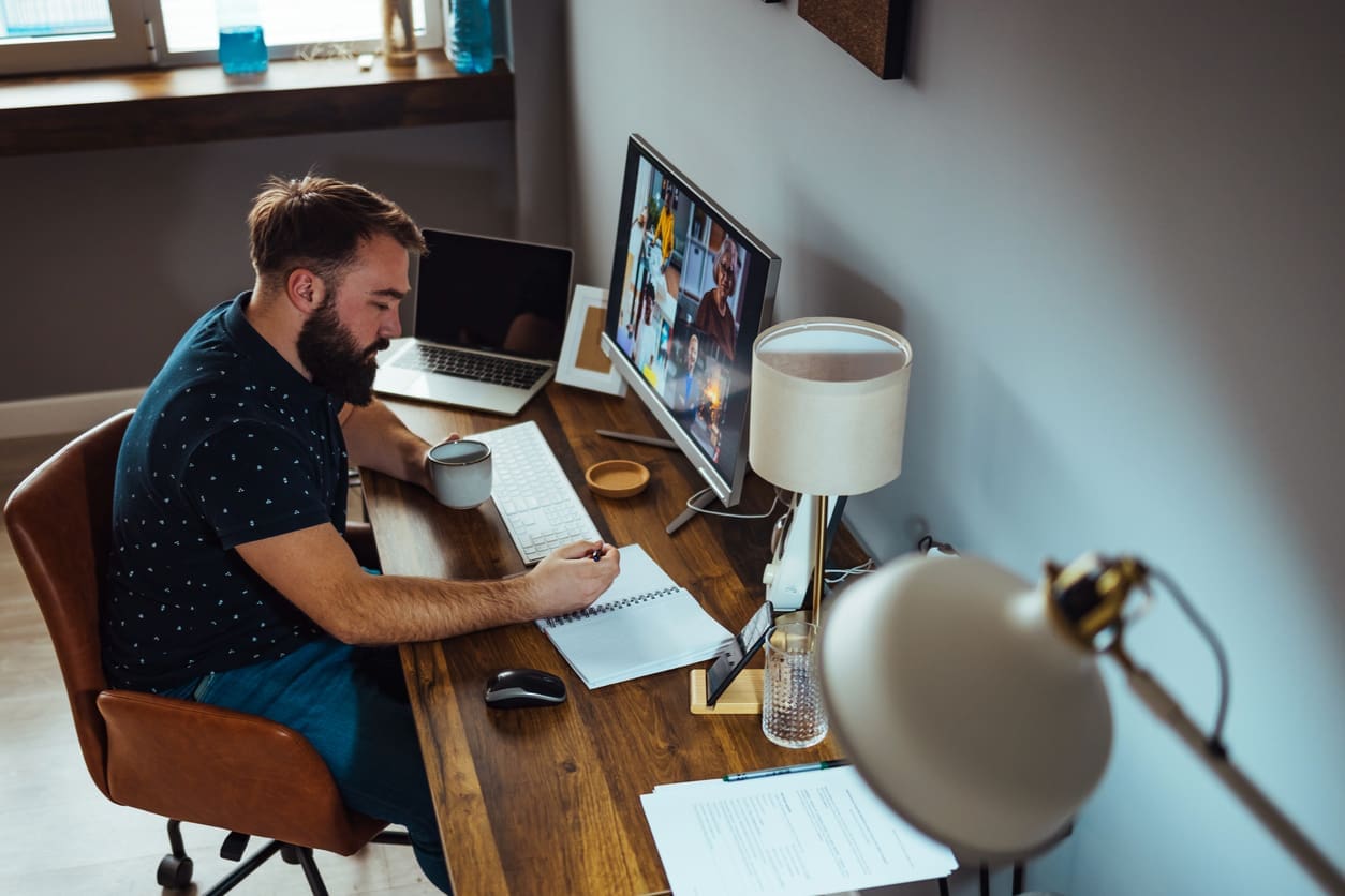 Job flexibility for remote workers - A male employee working at home and having an online meeting with his colleagues.