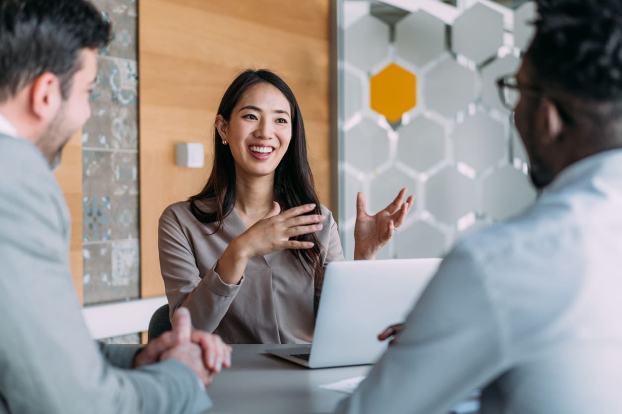 EOR risk mitigation - A female HR professional having a meeting with two businessmen.
