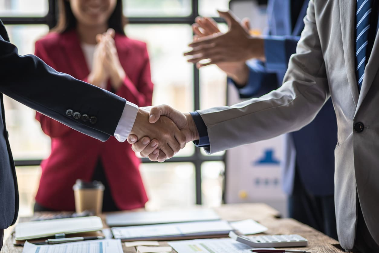 Scaling operations across borders - Two business partners shaking hands during a business agreement.