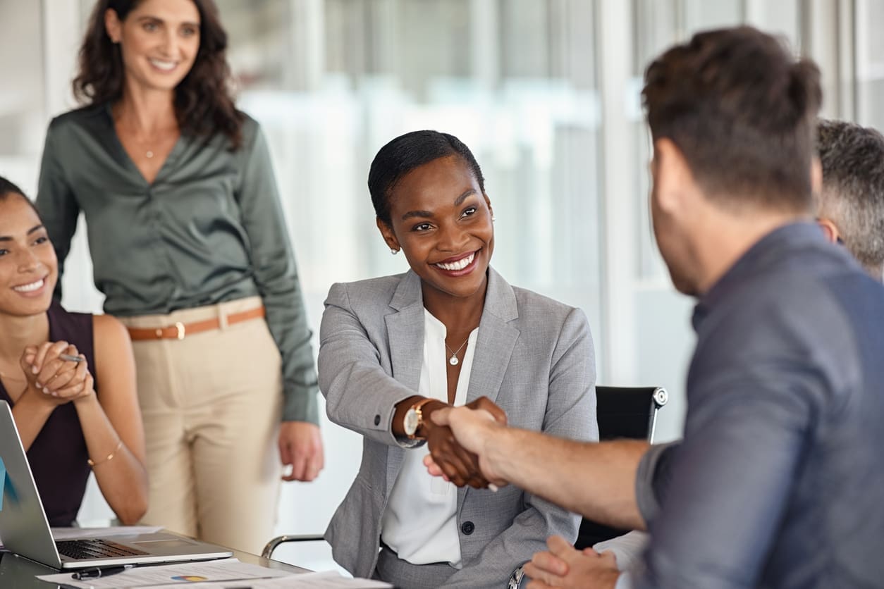 EOR risk mitigation - A businesswoman shaking hands with a businessman.