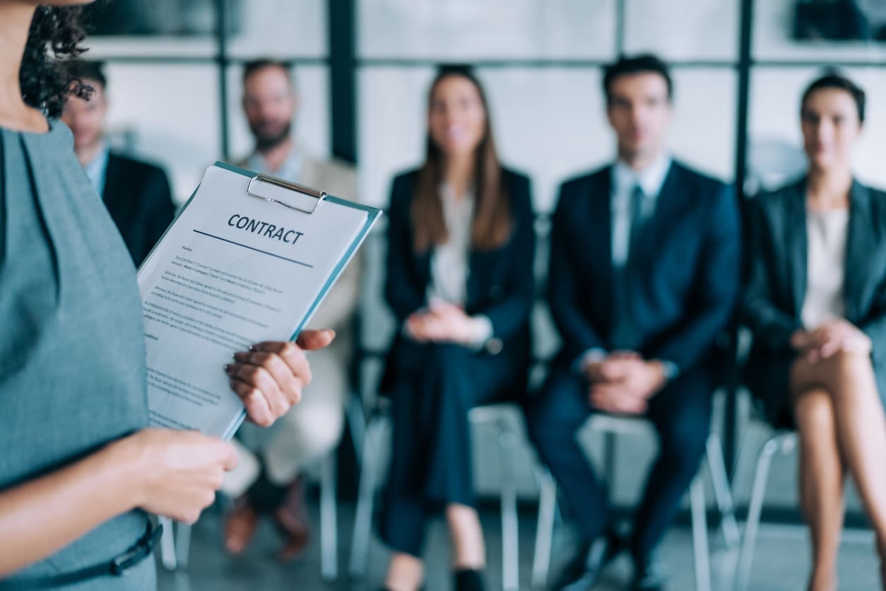 Business localization - A group of employees waiting in line for their interview.