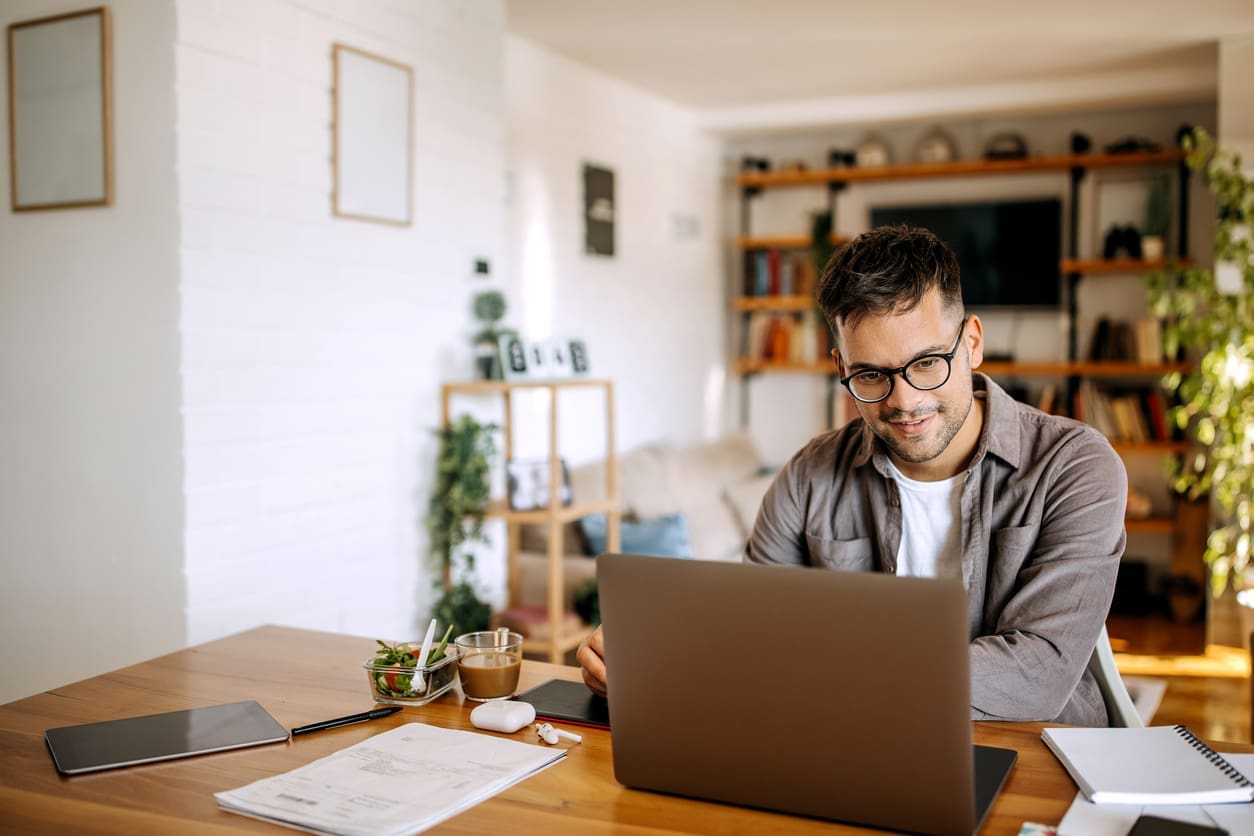 Work-from-home productivity - A man working at home using his laptop to perform his work tasks.
