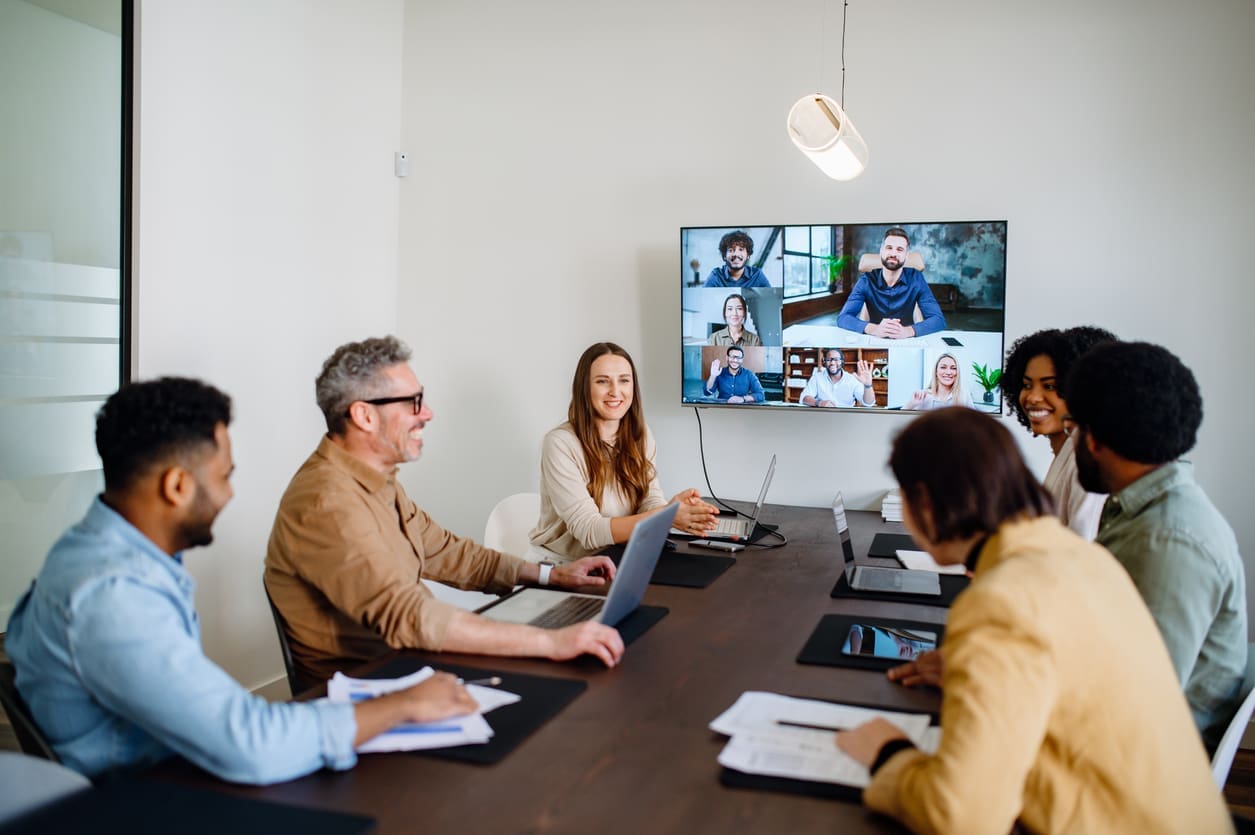 Improving team collaboration - A group of managers having a meeting with their remote team.