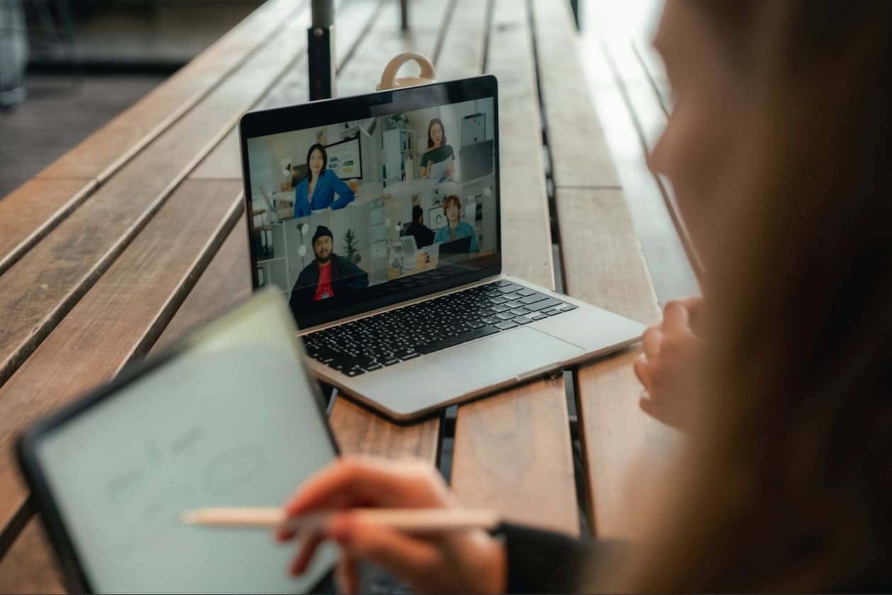 Team collaboration strategies - Two remote employees working on their tasks while talking with their colleagues online.