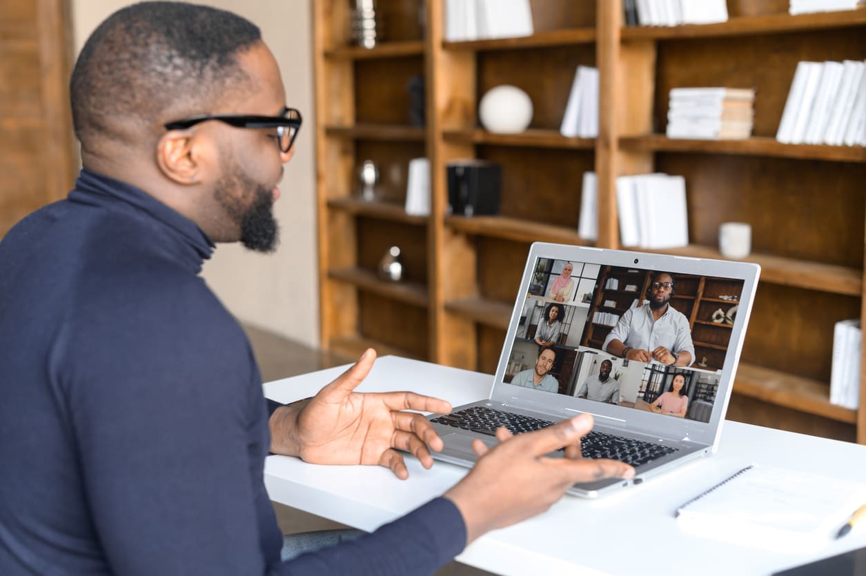 Global remote teams - A businessman using his laptop to conduct a virtual meeting with his employees.