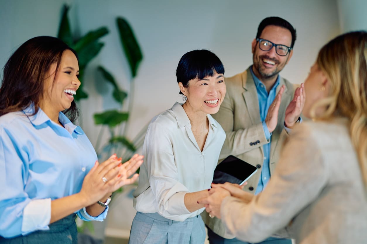 Employee engagement - A female manager shaking hands with a female employee, recognizing her contribution in the workplace.