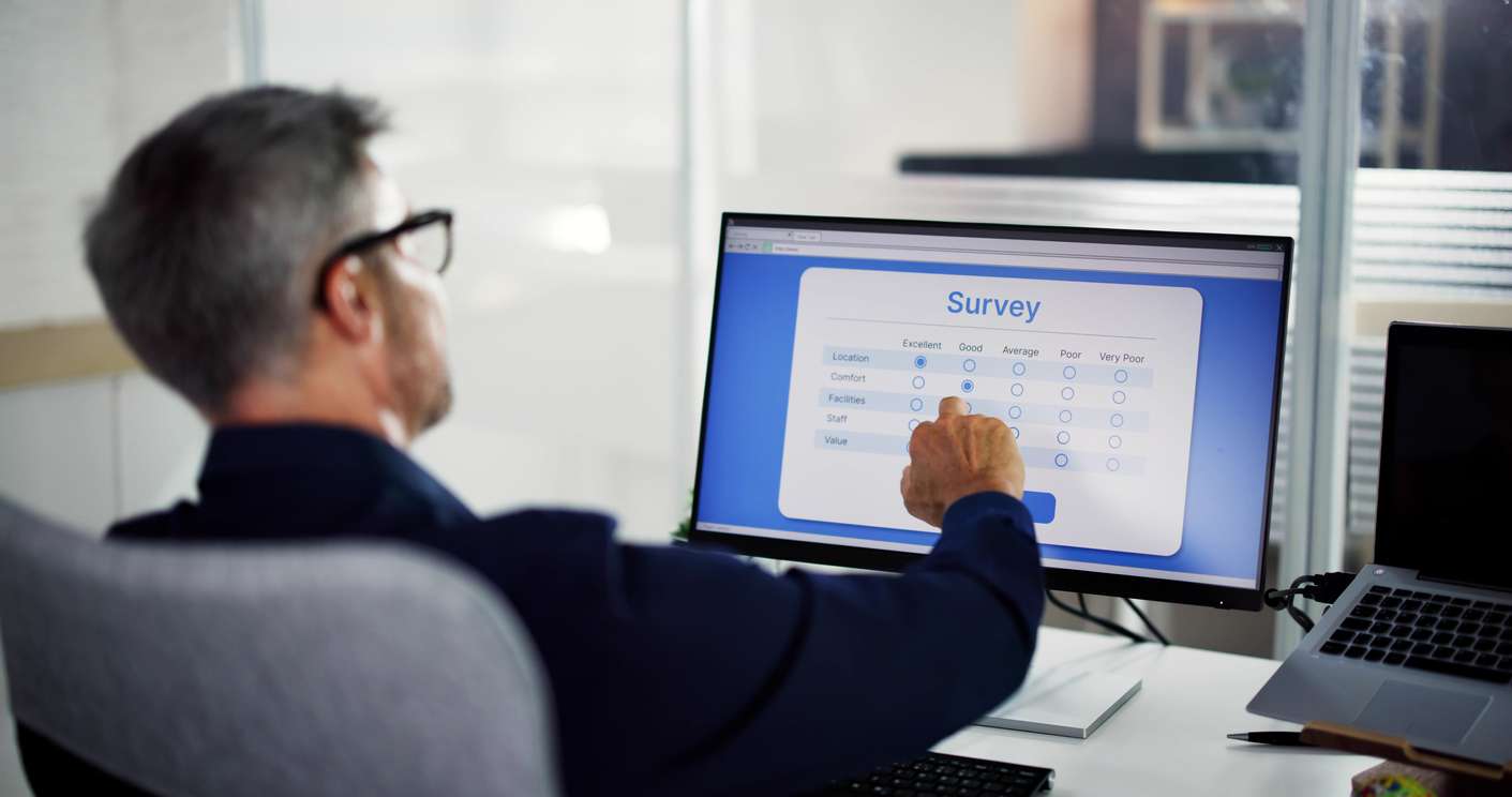 Employee Feedback Survey Form • BrightR Male employee answering an online feedback form using a computer.