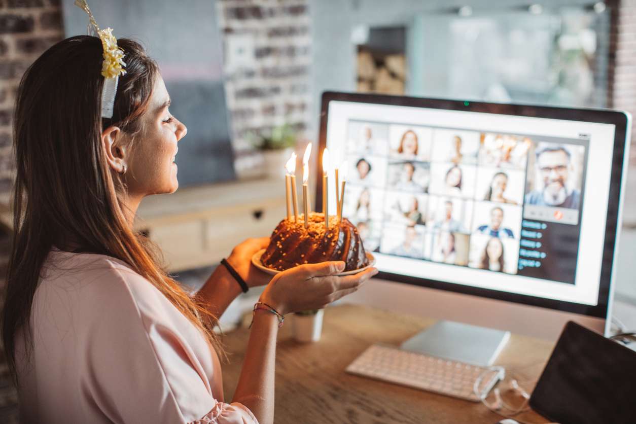 Celebrating with remote teams - Woman working from home celebrating her birthday with her colleagues online.