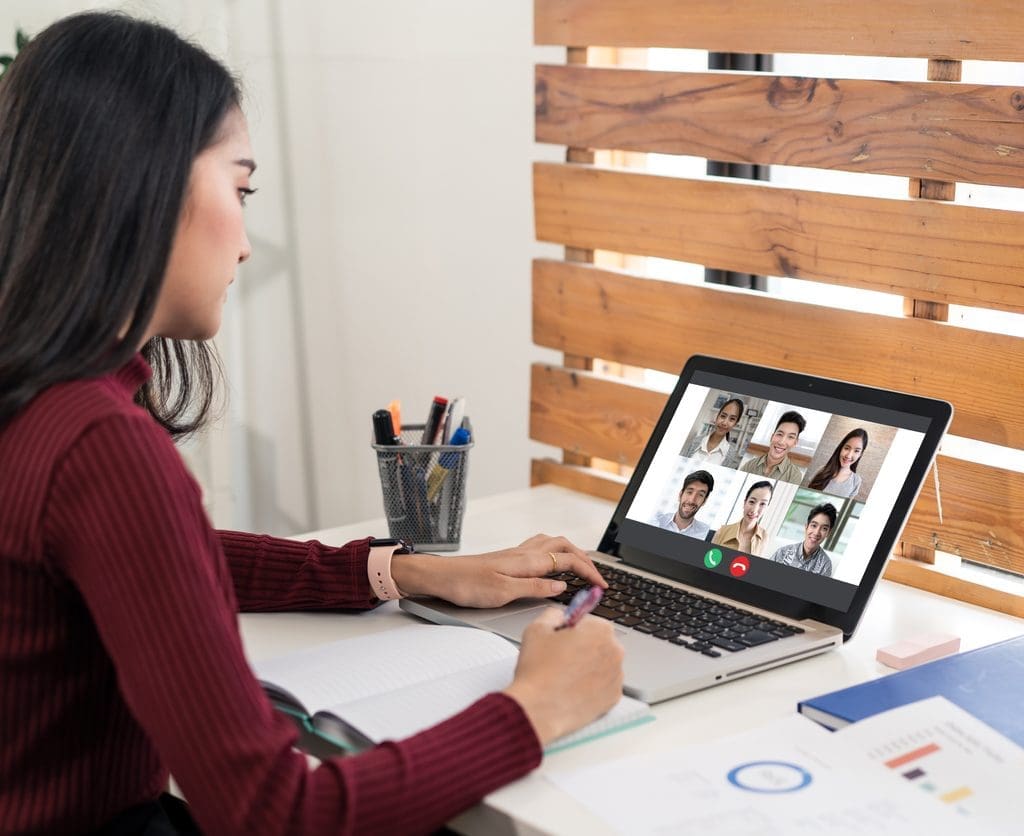 Woman talking to colleagues through video conference.