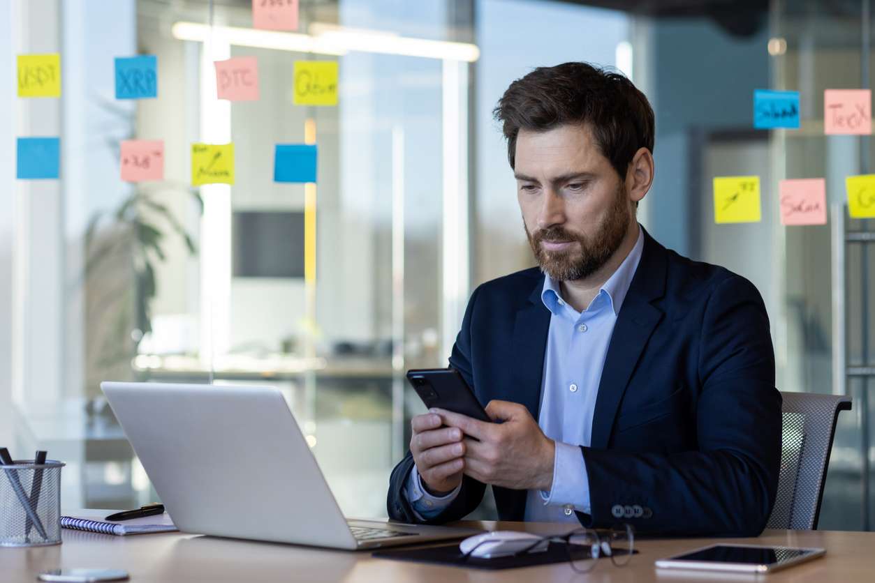 Respecting employees' right to disconnect. • BrightR Respecting international standards for internal communications - A male manager using his smartphone to message his employees.