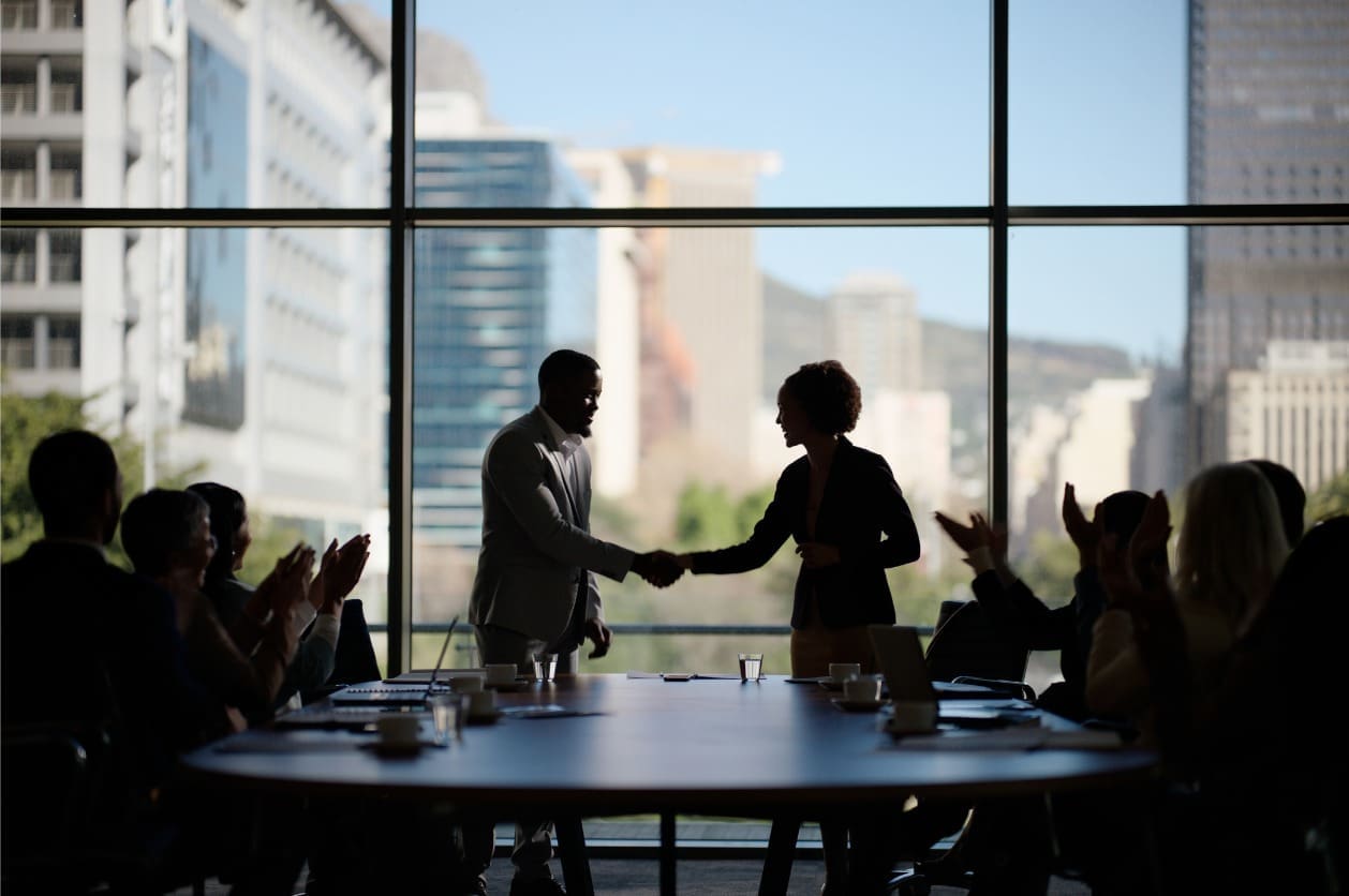 Local network for global expansion - A businessman shaking hands with a female business partner during a company meeting.