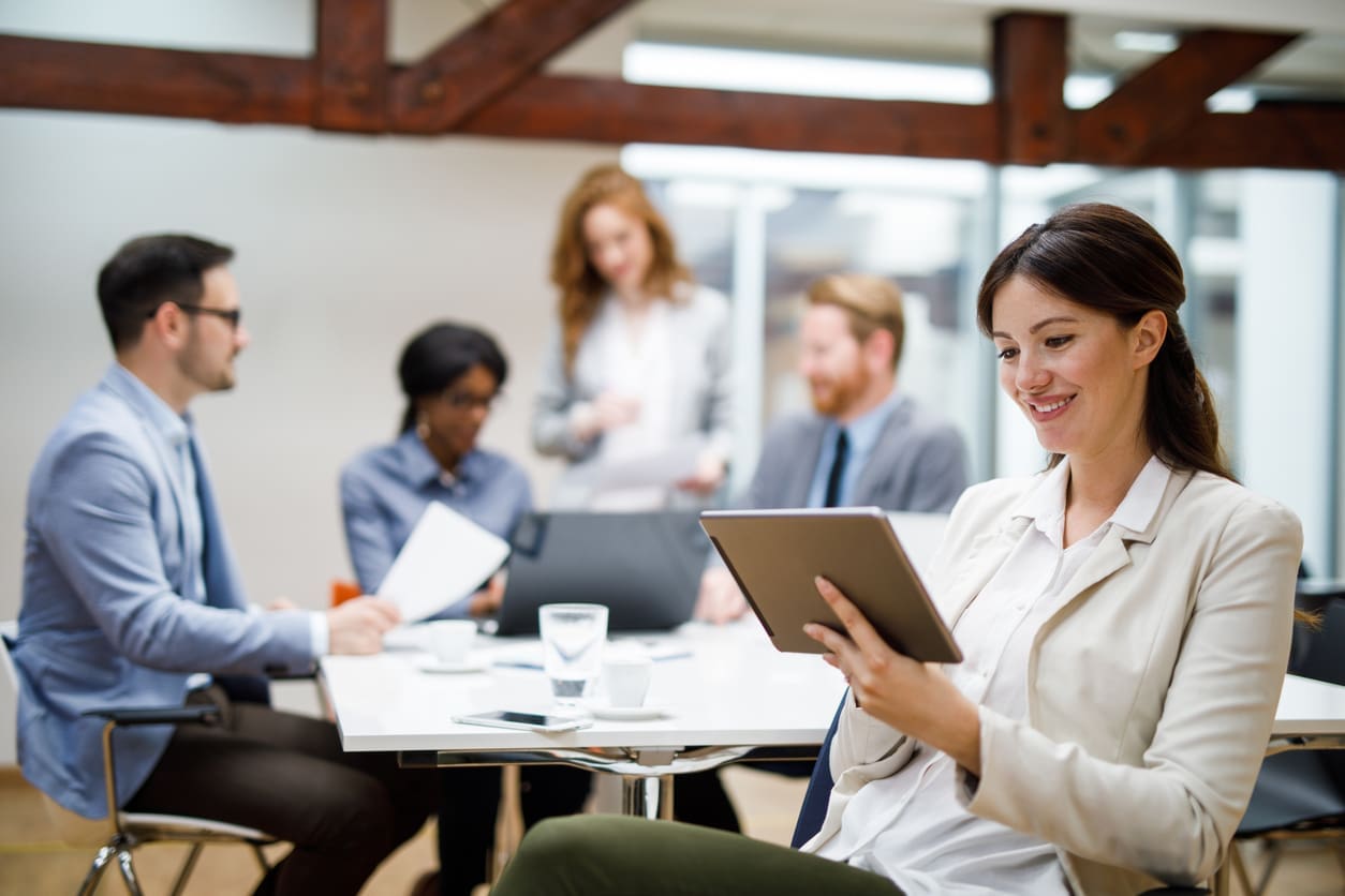 Assessing remote team success - A businesswoman using a tablet device to check her team's task performance.