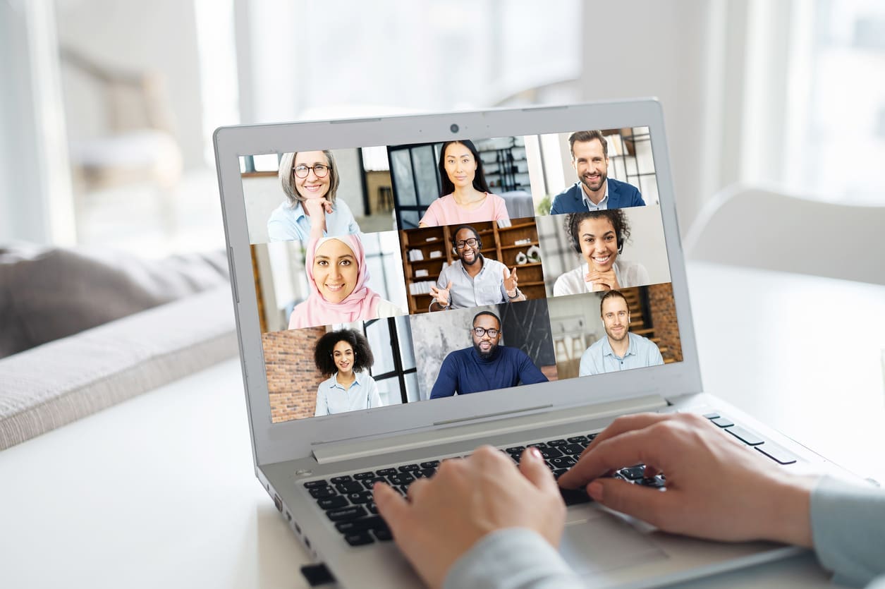 Diversity and inclusion in remote teams - An employee using a laptop while having a meeting with his diverse, international colleagues.