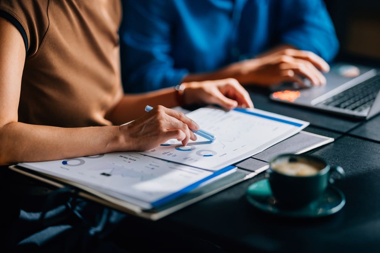 Cost-effectiveness of EOR services - A businesswoman reviewing business graphs during a meeting.
