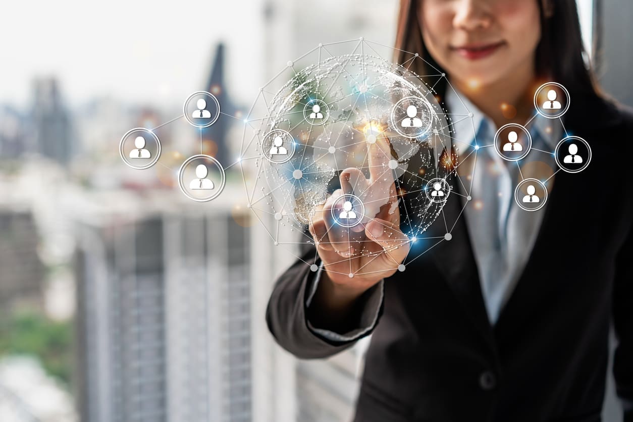 Cross-border recruitment - A businesswoman pointing at a digital globe showing international recruitment.
