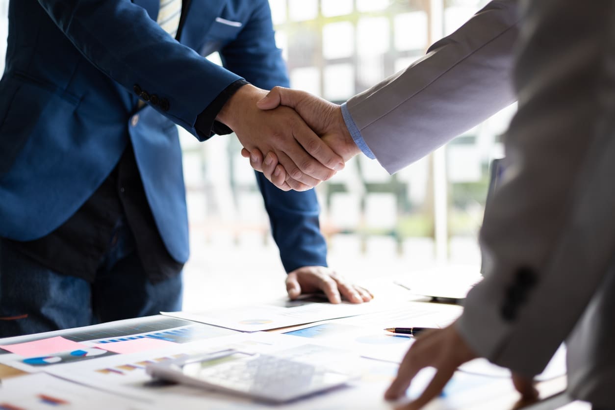 Business localization strategies - Two businessmen shaking hands during a contract agreement.